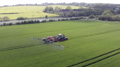 Tractor Spraying Green Field From Above