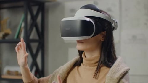 Woman in a Helmet of Virtual Reality Against the Background of a Huge Window in the Office at the