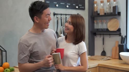 Smiling Couple Embracing and Drinking Coffee Together