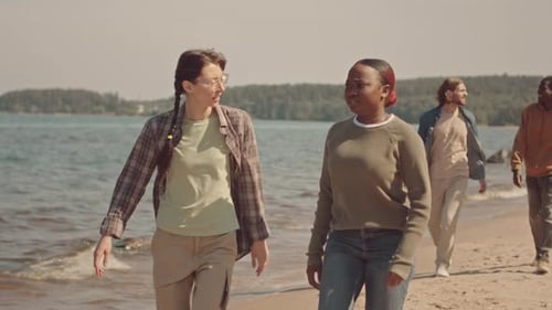 Multiethnic Friends Strolling along Sandy Beach