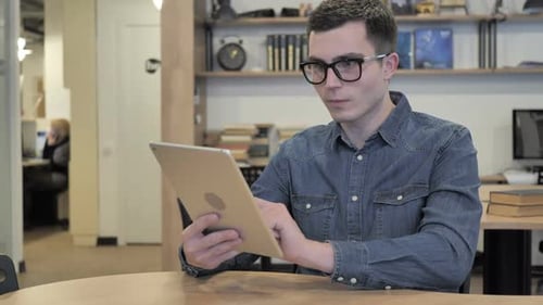 Man Using Tablet Expressing Surprise in Office