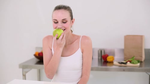 Smiling Model Smelling A Green Apple