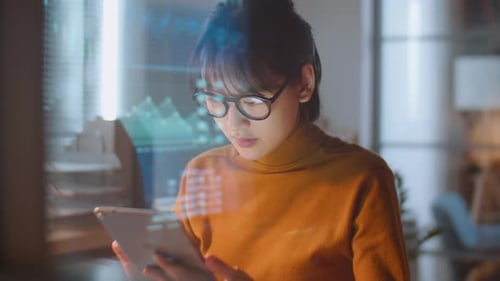 Female Stock Market Trader Using Tablet in Office at Night