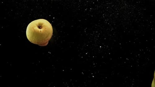 Yummy Fruits Red and Yellow Pears Falling Into Water with Splash and Air Bubbles Black Background