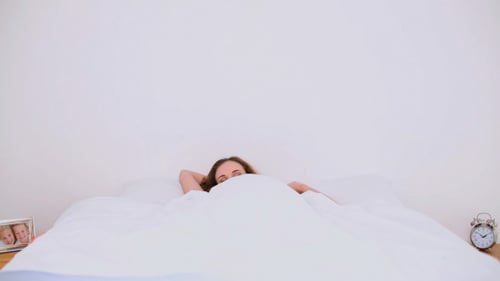 Woman Waking Up and Stretching in Bed