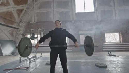 Woman Lifting Weighted Barbell during Cross-Training