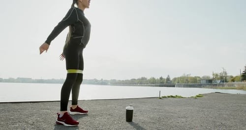 Athletic Woman Doing Squats by Lake