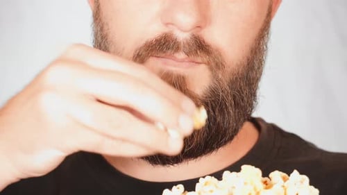 Bearded Man Enjoying Popcorn in Close Up