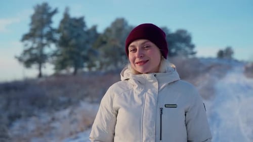 Portrait female person stay at winter forest outdoors. Attractive woman looking at camera outside