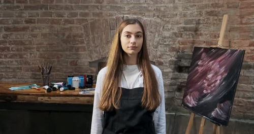 Young Woman Artist in her Studio with Brushes