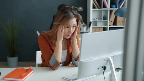 Exhausted Office Worker Suffering From Headache Working at Computer Desk