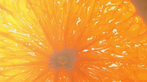 Ein Wassertropfen fließt über die Oberfläche einer reifen, saftigen Orangenscheibe