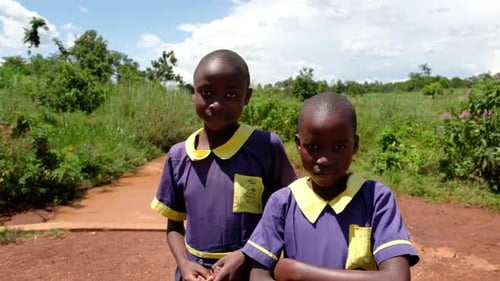Children in Uniform Standing in Rural Landscape