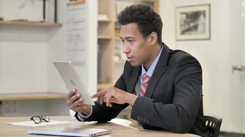 Excited Man Looking at Tablet in Office
