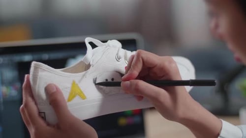 Close Up Of Female's Hands Putting Coloured Unique Patterns On Sneakers While Designing Shoe