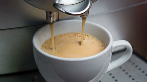 Pouring Coffee into White Mug from Machine