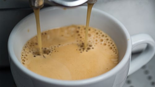 Coffee Maker Pouring Fresh Espresso into White Mug