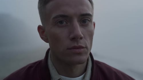 Young Man Turns to Face Camera in Mist