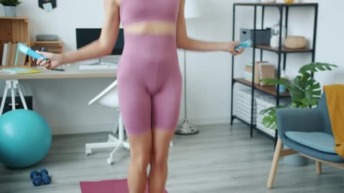 Woman Exercising with Jump Rope Indoors
