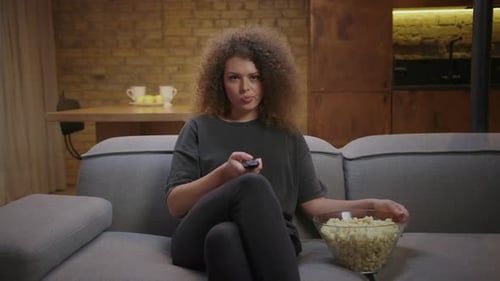 Woman Relaxing, Watching TV, and Eating Popcorn