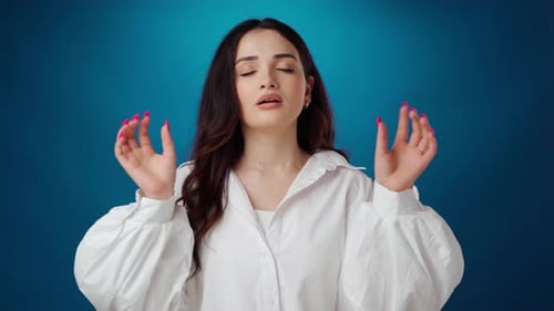 Woman Meditating Against Blue Background