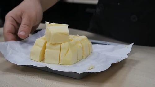 Man Chef Weighs Creamy Margarine or Butter Cut Into Pieces on a Scale