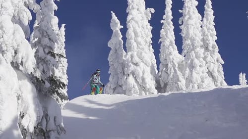 Ein Mann fährt im Winter einen schneebedeckten Berg hinunter.
