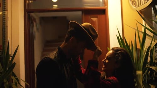 Woman Puts Hat on Man at Night