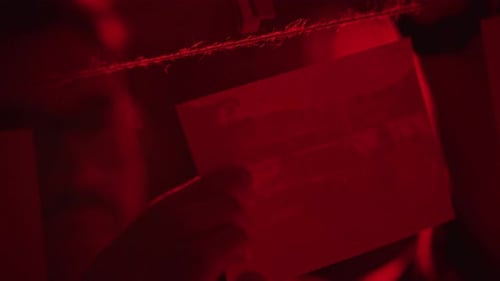 Photos Hanging by Clothespins in Moody Red Light