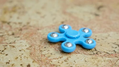 Blauer Handspinner zum Drehen auf einem Holztisch