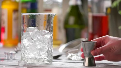 Hand Adding Liquid to Cocktail with Ice