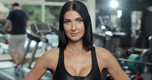 Portrait of Sport Fit Girl Stand and Smiling in Gym or Fitness Club with Work Out Machine Behind in