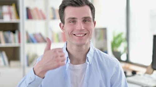 Happy Young Adult Smiling and Giving Thumbs Up