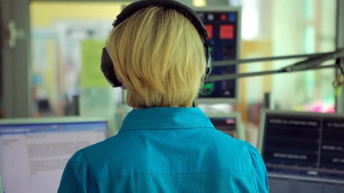 Moderadora de radio femenina en la sala de prensa, vista trasera