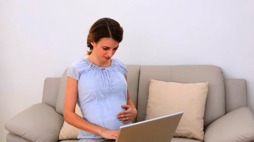 Pregnant Woman Using Laptop Indoors on Couch