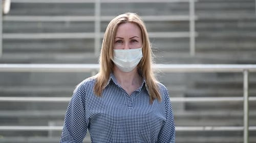 A Masked Girl in the Background of a Ladder in a Public Place of the City During a Quarantine