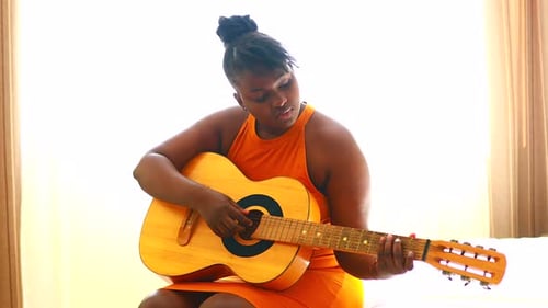 Woman Playing Acoustic Guitar Indoors During Daytime