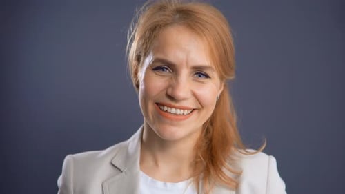 Charming Smiling Blond Posing in Studio on Blue Background