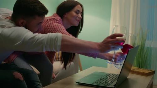 Young Couple Video Chatting with Wine at Home