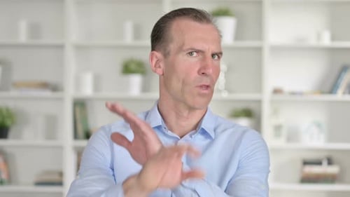 Portrait of Middle Aged Businessman Saying No with Hand Gesture