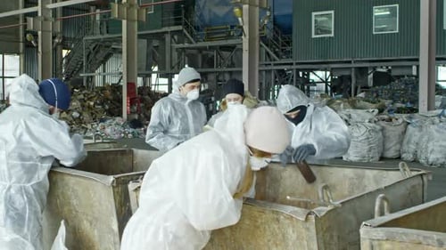 Workers Manually Sorting Waste at a Recycling Plant