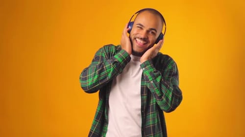 Man Enjoys Music with Headphones, Smiling and Dancing