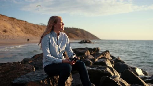 Photographer With Slr Camera And Looking Out To Sea