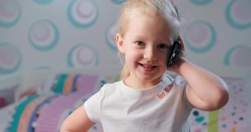 Happy Child Chatting on the Phone Indoors