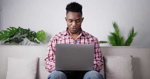 Man Works on Laptop From Home Living Room