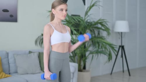 Woman Doing Bicep Curls with Dumbbells at Home