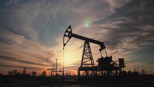 Oil Pump Jack Working at Sunset