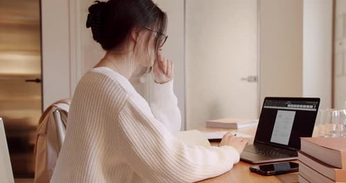 Beautiful Young Woman in Glasses Works on Laptop Computer While on Office