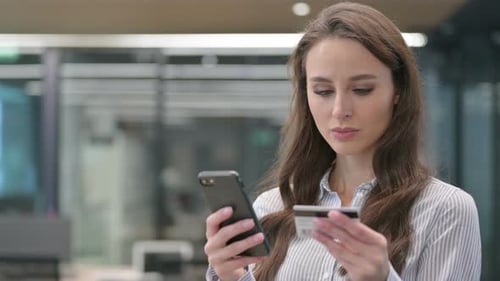 Worried Woman Using Credit Card with Smartphone