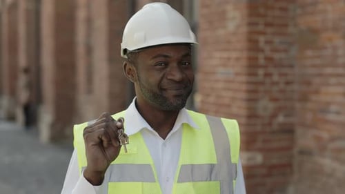 Porträt eines Ingenieurs mit Schlüsseln aus dem neuen Zuhause